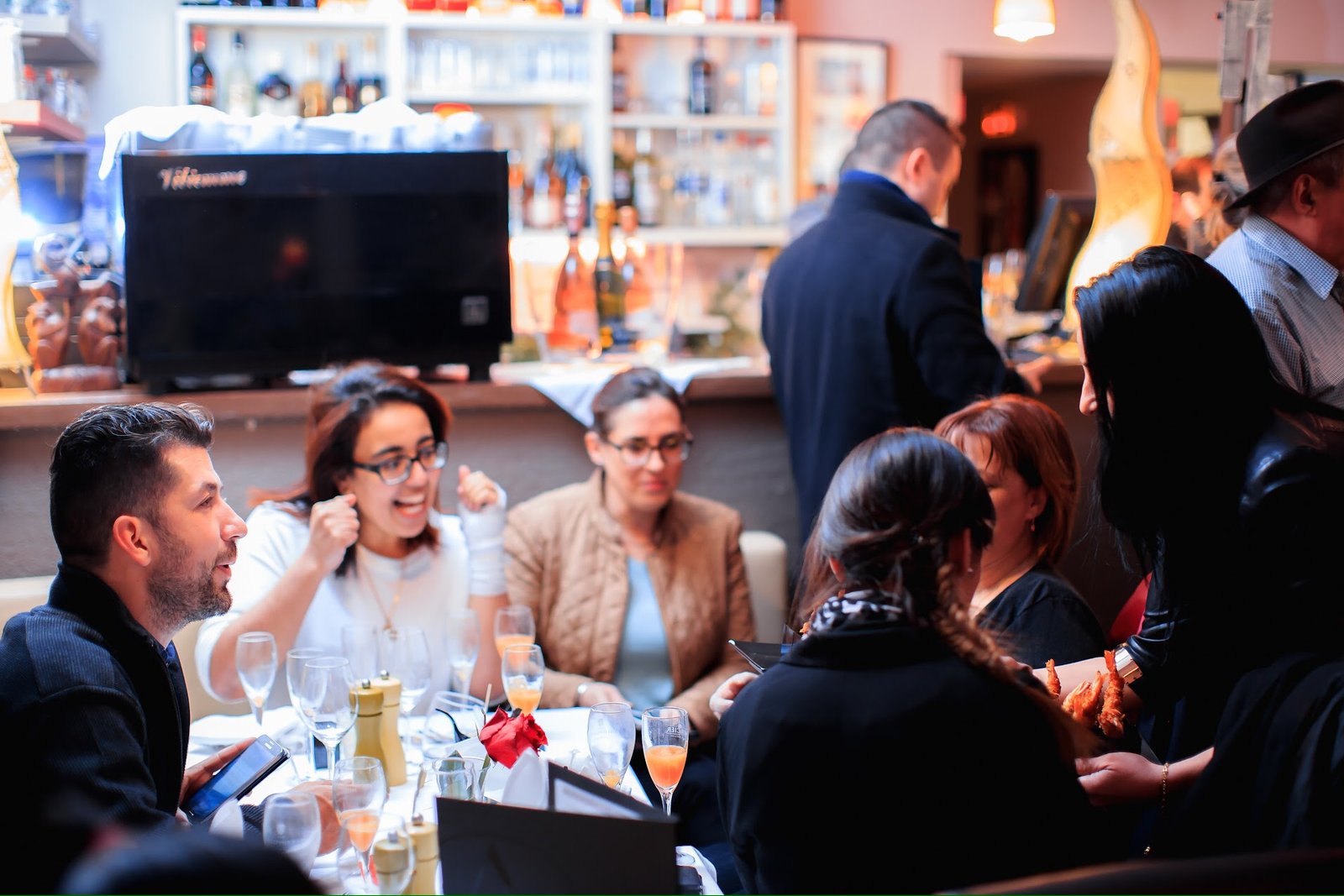 Un groupe d'amis partageant un moment convivial autour d'un repas au restaurant Ôazar, avec une ambiance chaleureuse et festive.