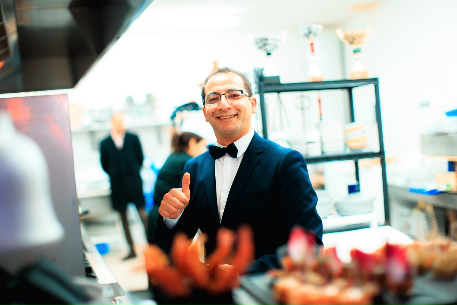 Chef Salah dans la cuisine de Ôazar, souriant et montrant un pouce en l'air.