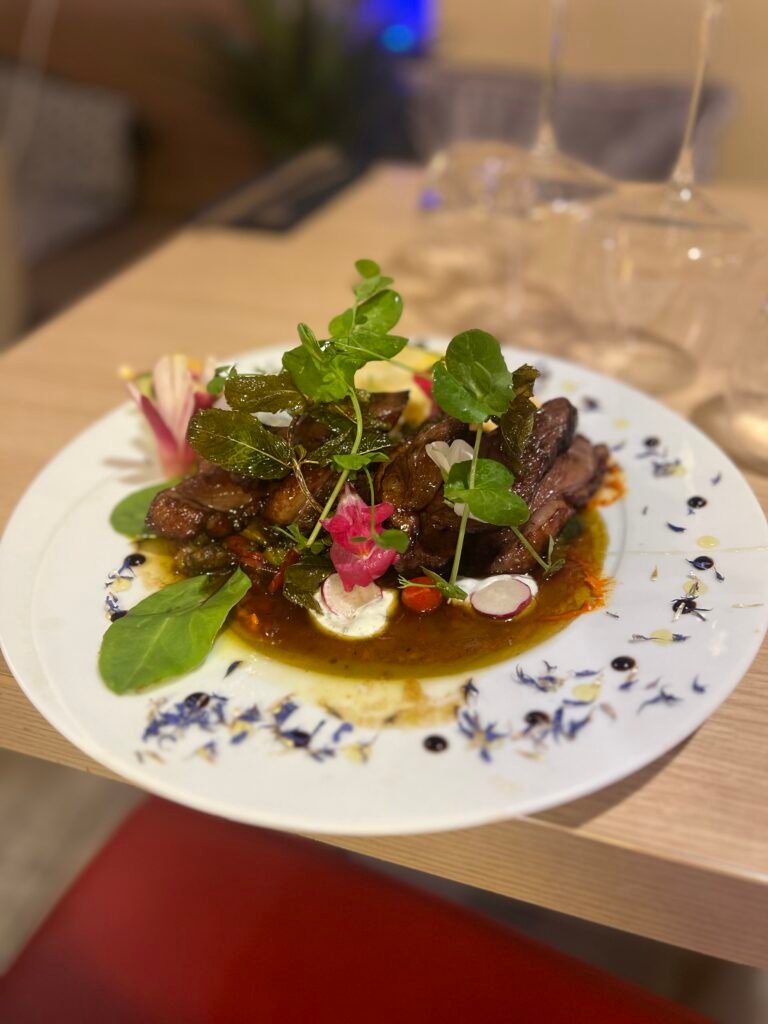 Magret de canard délicatement préparé au restaurant Ôazar à Cavaillon, servi avec une sauce raffinée et des garnitures fraîches.