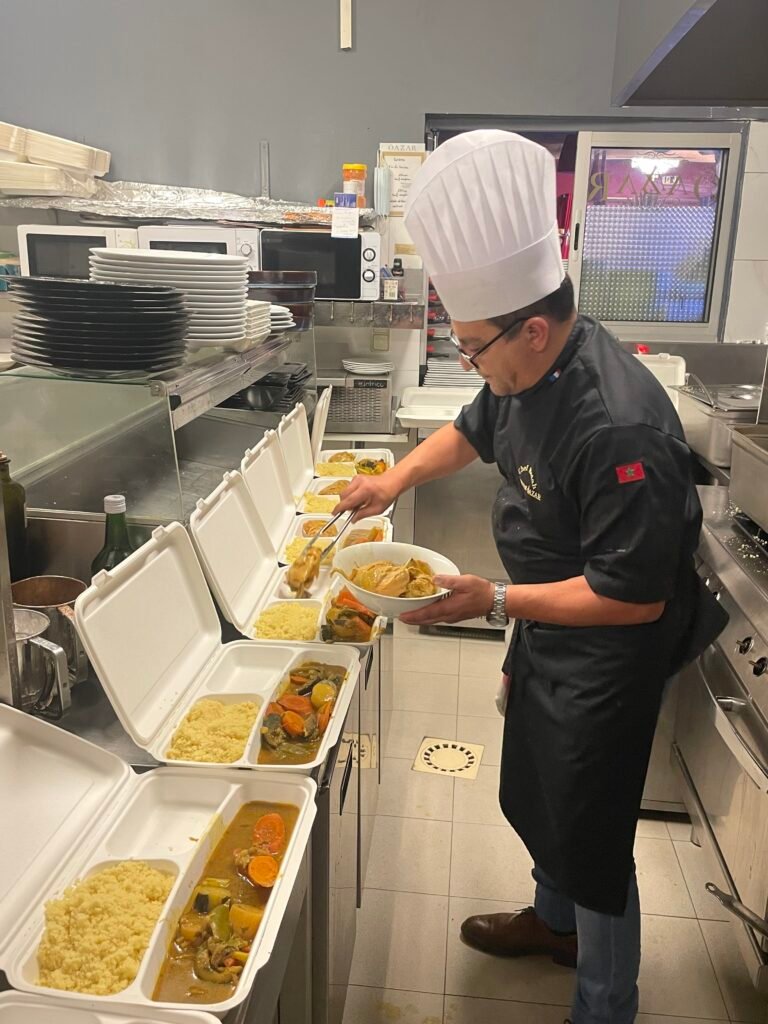 Chef en train de préparer des plats de couscous pour la livraison au restaurant Ôazar.