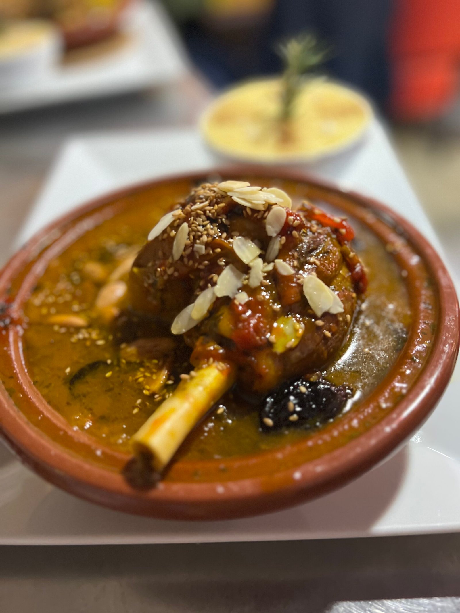 Tajine d'agneau aux fruits secs préparé au restaurant Ôazar à Cavaillon, un plat traditionnel marocain garni d'amandes effilées et de pruneaux.