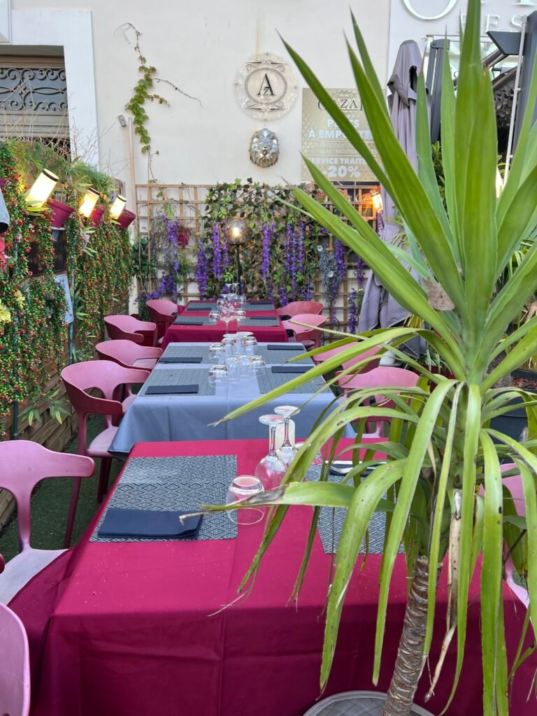 Terrasse du restaurant Ôazar à Cavaillon, joliment décorée avec des plantes et des fleurs, offrant une ambiance agréable pour un repas en plein air.